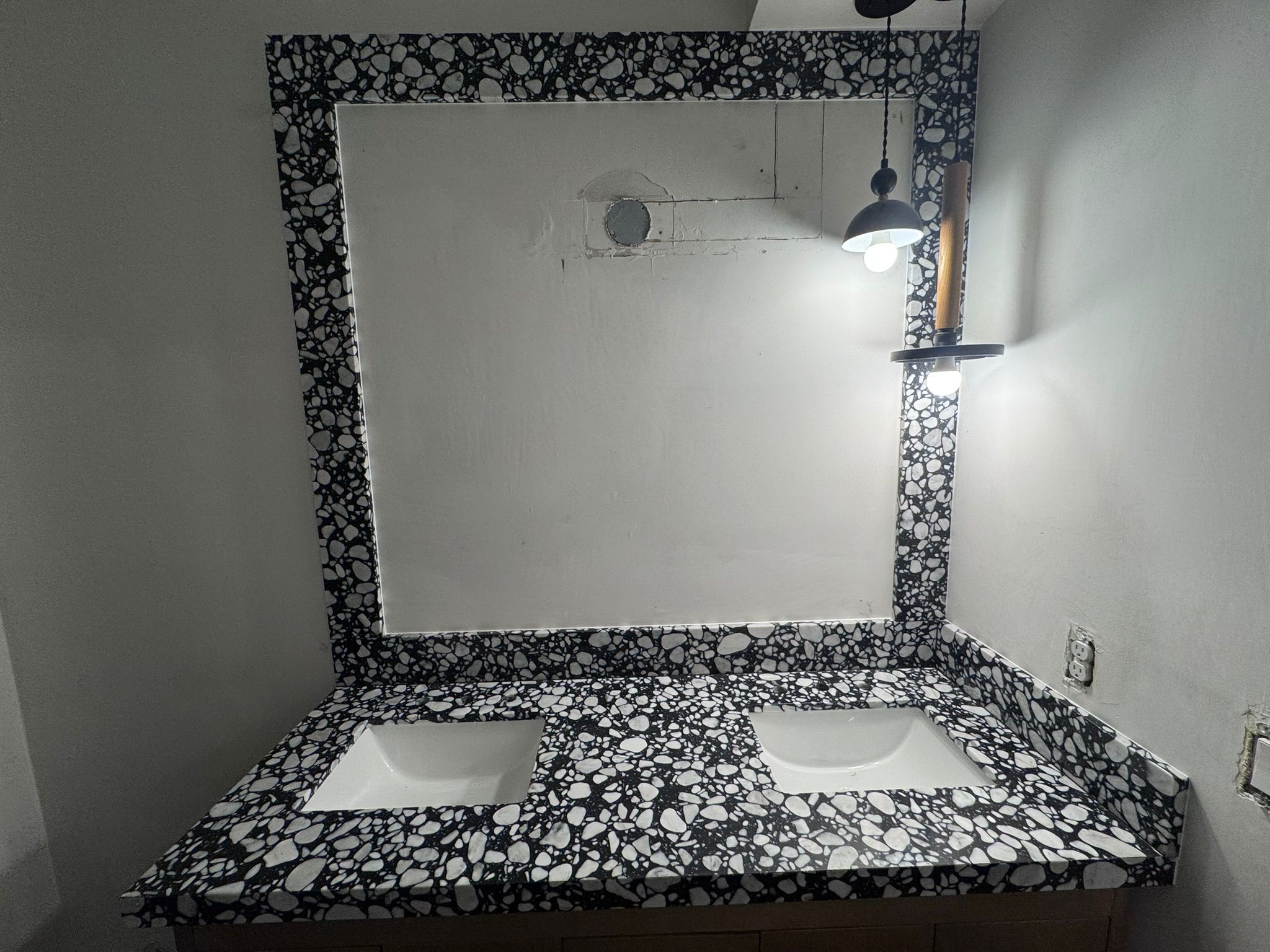 Designer bathroom with terrazzo countertop and mirror frame